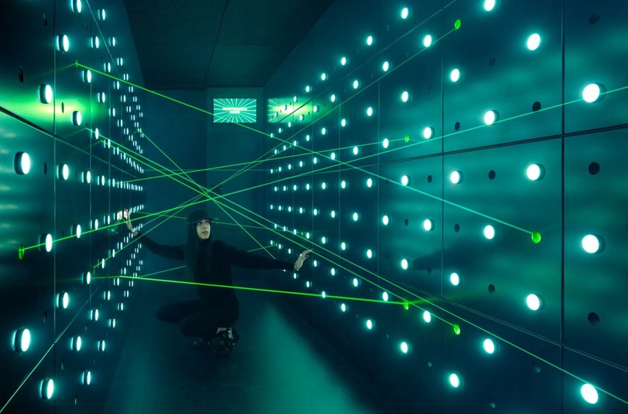 A marketing image for the Spyscape museum, showing a person navigating the classic Room Full Of Security Lasers challenge you see a lot in Hollywood films, and never in reality.